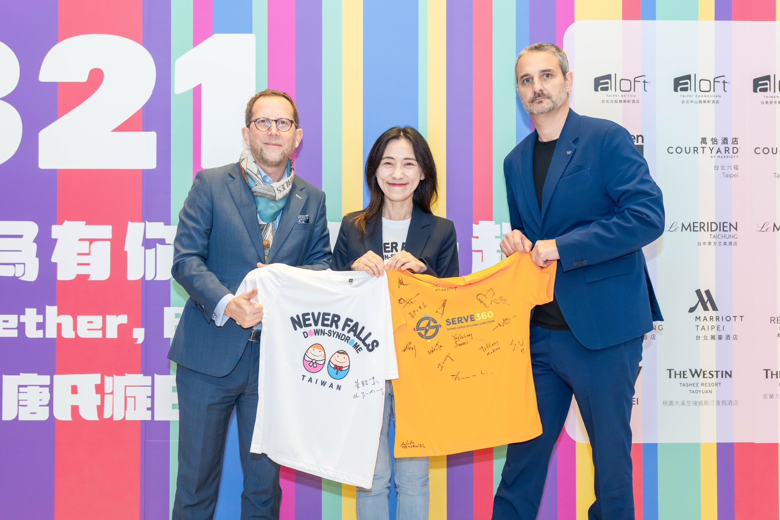 萬豪國際港澳台海南區區域副總裁 Richard Boyer（左）、萬豪國際集團台灣市場總經理哲仁廷Bastien Giannetti（右）代表全台32間萬豪旗下酒店，與唐氏症基金會副執行長朱貽莊（中）共同簽署合作意向，互換象徵攜手併進的品牌簽名T恤。圖 大溪笠復威斯汀提供